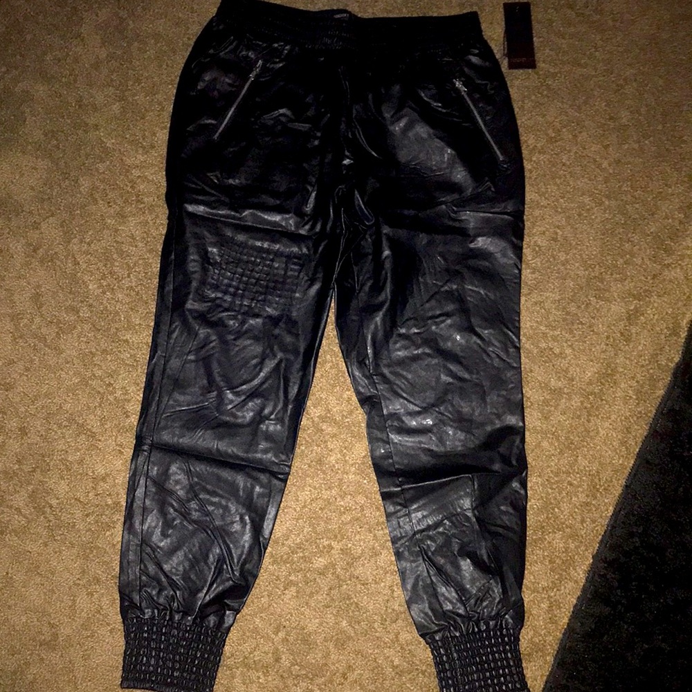 Black faux leather joggers. Zipper pockets